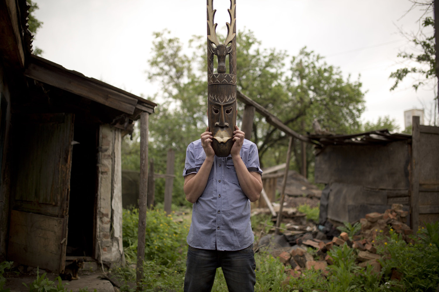 Tolek (23), playing with a mask he carved out of wood. In life he has learned to do many things, including carpentry which is what he would really like to do in life. He isn't too optimistic about it: without money or anybody to help, becoming a carpenter will most likely remain a distant dream, as will the dreams of many other young miners of the Donbass.