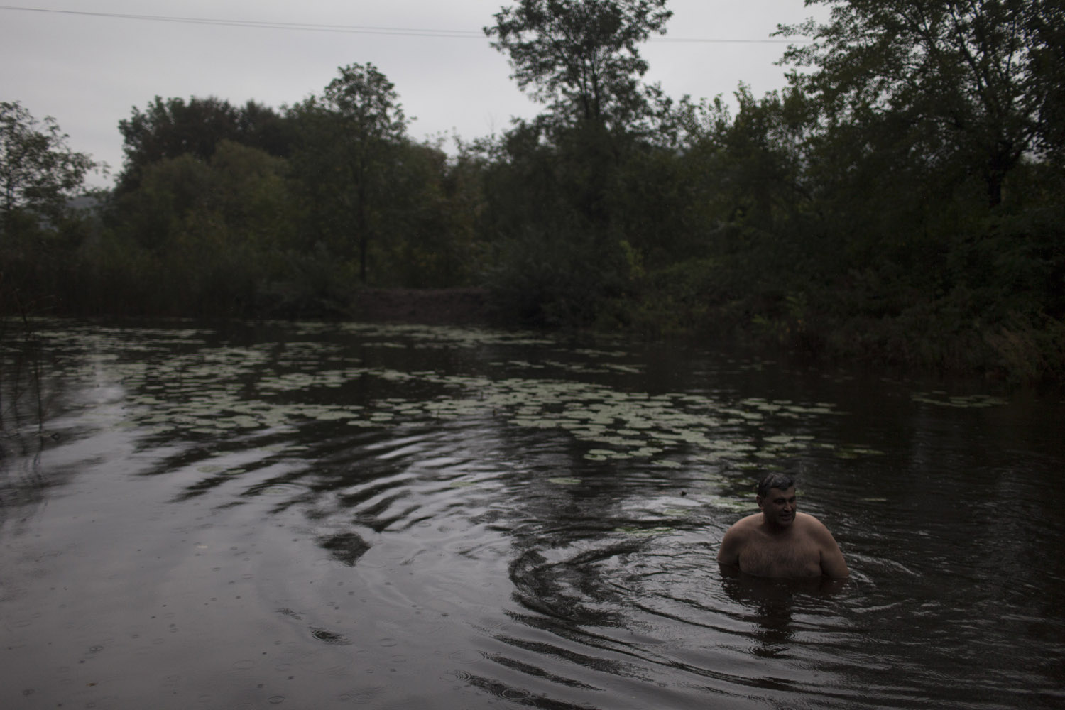 On a rainy and cold day, Vasily takes a dip in a small pond near his brother's house, which they use as a mikve (ritual bath) before the holidays.