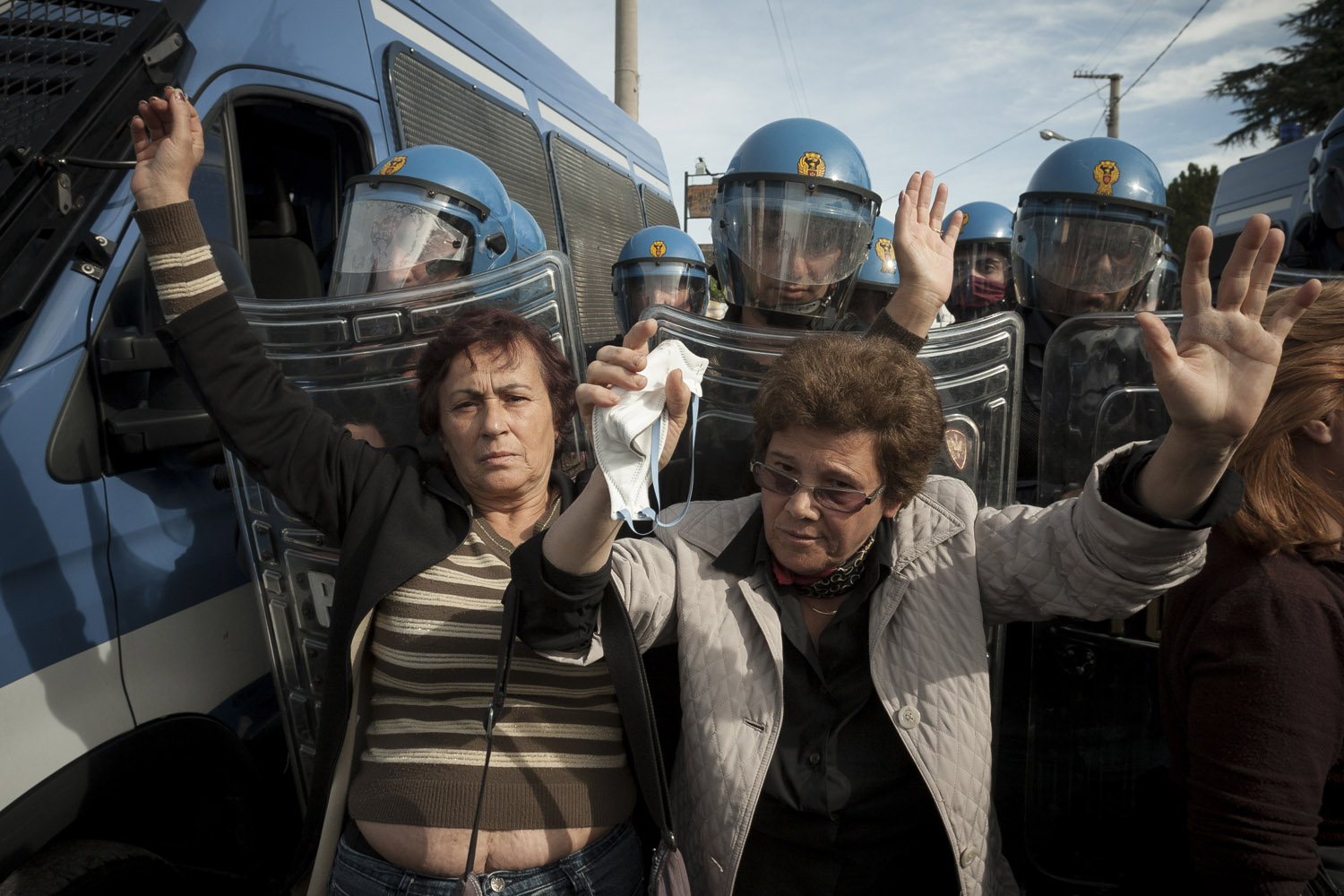 Two women from the “Volcanic Mothers” committee try to break through police lines and access Cava Sari. As the protests intensified and the garbage piled up in the streets of Napoli, a massive police deployment guarded the garbage dump and the roads leading to it. The dispersal of this group of women on the 18th of October led to the first violent clashes and provided the spark to set the situation on fire.