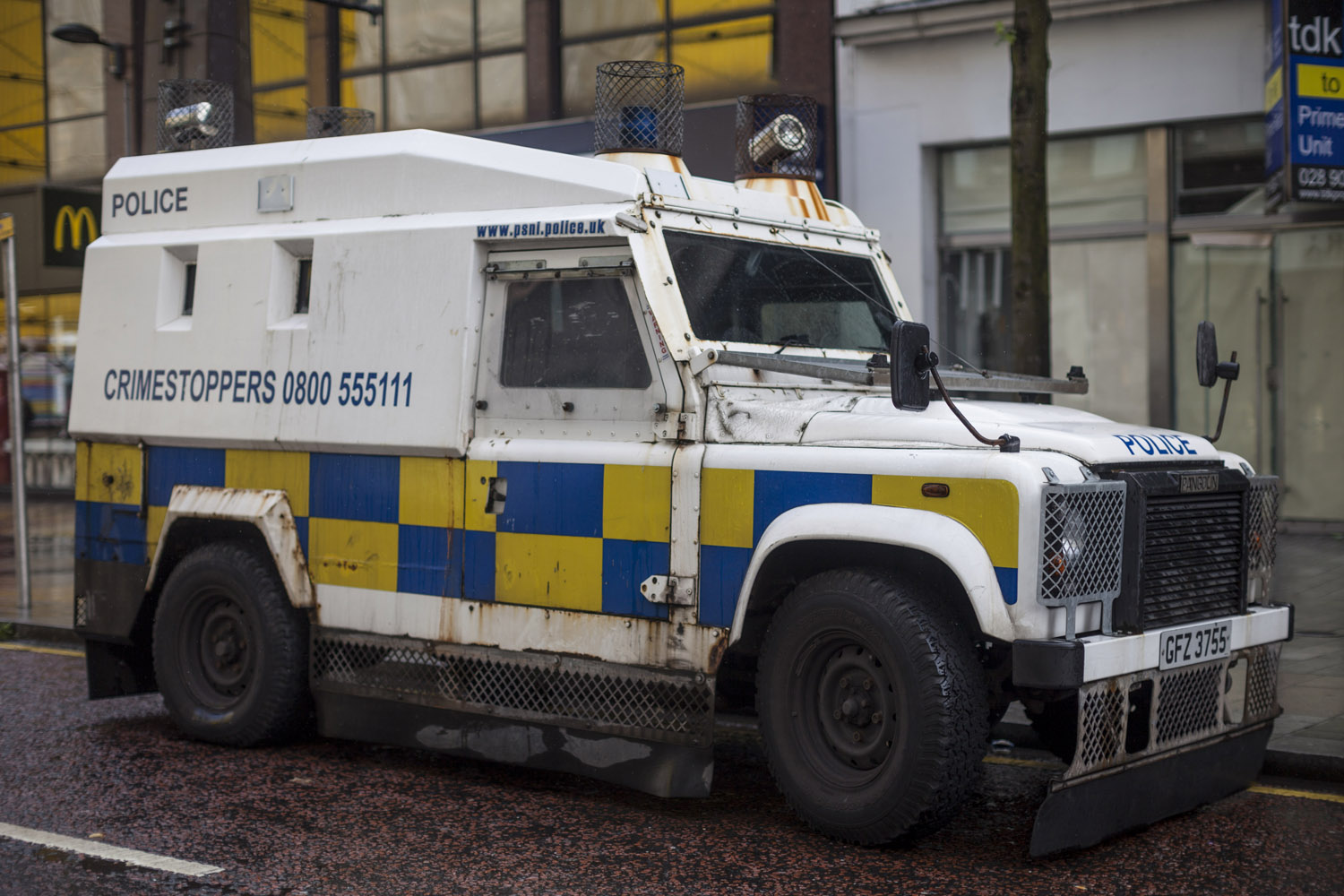 Police in the centre of Belfast protecting a Protestant parade. After decades of violence, a significant portion of the police's vehicles are practically armoured cars, and police stations are fortified with protective cages and bullet-proof windows, even after the police was reformed under the Good Friday Agreement, turning from the largely Protestant RUC (Royal Ulster Constabulary) to the neutral and theoretically mixed PSNI (Police Service of Northern Ireland).