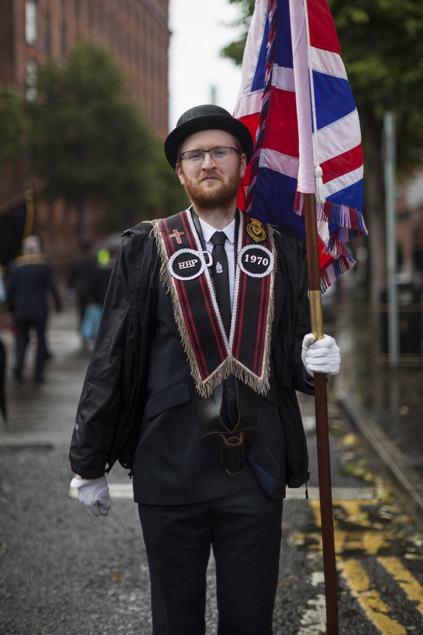 A member of a Protestant “Loyal Order” poses for a portrait at the end of a rainy parade in the centre of Belfast. Commemoratory parades with marching bands and other regimented displays of British patriotism are a central element of Protestant culture, and remain a source of frictions, especially when their routes bring them through Catholic neighbourhoods.